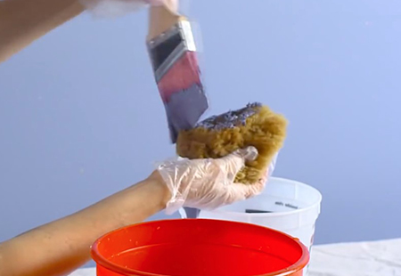 Aplicando pintura en la esponja con una brocha