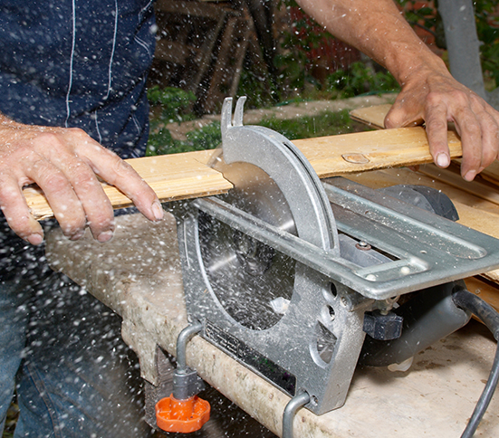 Usuario cortando madera con una sierra circular doméstica
