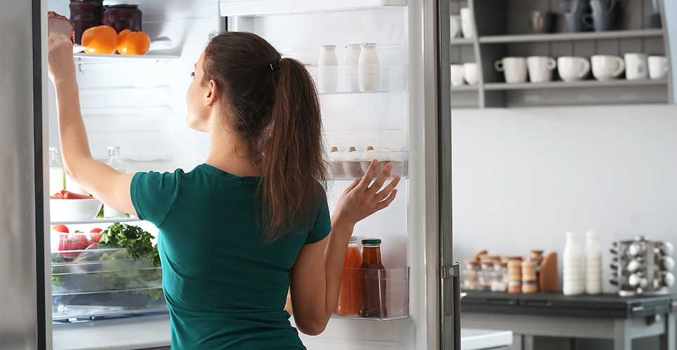 Usuaria acomodando alimentos dentro del refrigerador