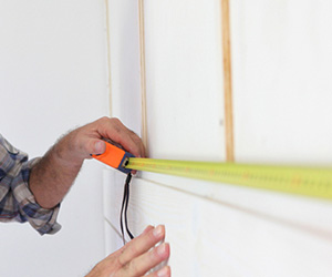 Persona utilizando cinta métrica para medir pared