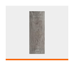 Tablón cerámico con formato alargado que imita las piezas de madera natural bajo un tono gris ceniza